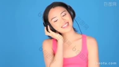 一个女人的肖像唱歌和通过耳机听音乐